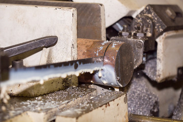 Band saw cutting metal, cooling emulsion, saw cuts metal contour disc.