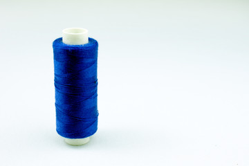 blue threads on reels selective focus, white background