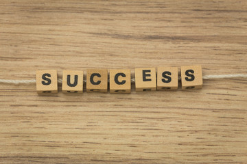 Fototapeta premium inscription / success / arranged from blocks strung on a string