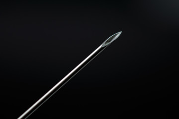 syringe needle on dark background concept of addiction selective focus