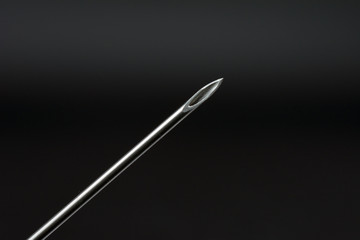 syringe needle on dark background concept of addiction selective focus