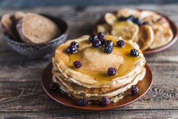 pancakes with honey and BlackBerry on a brown plate