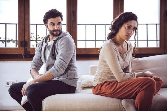 Couple not talking after a fight on the sofa in living room at home