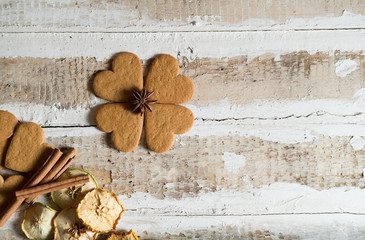 cookie hearts and chocolate with cinnamon sticks and slices of dried apples with text space on wooden background