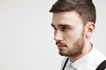 Half profile close up image of self determined focused young Caucasian unshaven businessman in...