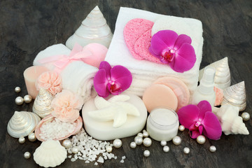 Cleansing spa and ex foliation beauty treatment with orchid and carnation flowers, moisturising cream, ex foliating salt, shell shaped soaps, sponges, wash cloths, body lotion with shells and pearls.