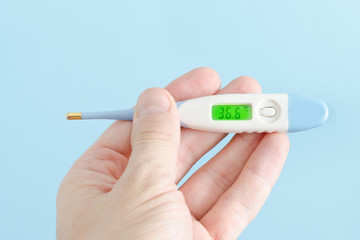 Electronic thermometer in a man's hand. Close-up