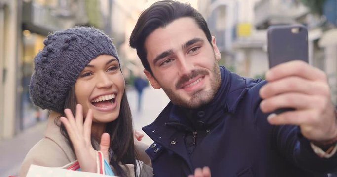 A couple of young engaged or friends, while they are shopping, having fun together, play and take pictures while they smile. Concept of: shopping, entertainment, friendship, love and leisure.