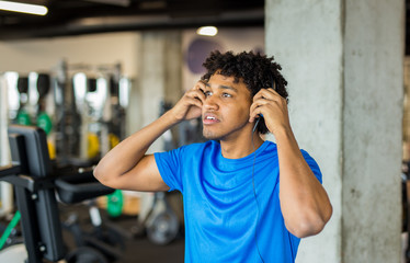 Handsome african american man working out at the gym while listening to music