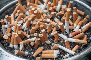 cigarettes dans un cendrier public plein
