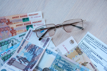 Russian money, glasses and receipts for pension are on the table