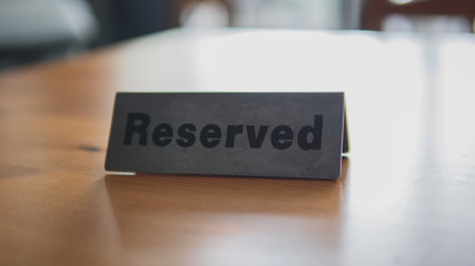 Reserved sign on top of a wooden table in a restaurant, Reservation seat at restaurant for dating on celebrate day concept, Restaurant with reserved on table with cafe decorate places setting.