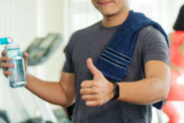 Blurred images man athletes holding a bottle of water and thumbs up.