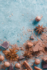 Dessert ingredients flat lay. Chunks of milk and bitter chocolate, spices and scattered cocoa on a stone background. Confectionery food photography.
