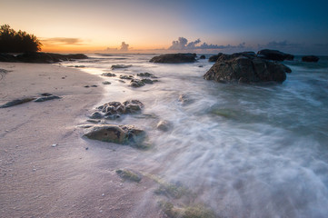 vibrant sky suring sunset with waves trails. image content soft focus due to slow shutter.