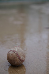 雨が降るグラウンドに落ちている野球ボール