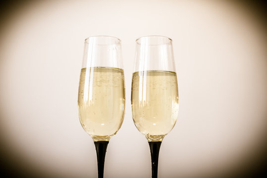     Two glasses of champagne stand on a white table 