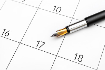 Pen on the calendar. Close up. Pen pointing on day 17 of the month at calendar.