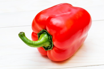 Sweet red pepper on white wooden table.