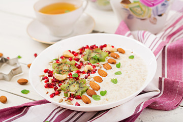 Tasty and healthy oatmeal porridge with kiwi, pomegranate and seeds. Healthy breakfast. Fitness food. Proper nutrition.