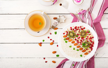 Tasty and healthy oatmeal porridge with kiwi, pomegranate and seeds. Healthy breakfast. Fitness food. Proper nutrition. Top view