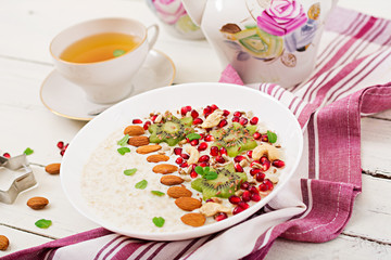 Tasty and healthy oatmeal porridge with kiwi, pomegranate and seeds. Healthy breakfast. Fitness food. Proper nutrition.