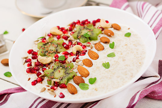 Tasty and healthy oatmeal porridge with kiwi, pomegranate and seeds. Healthy breakfast. Fitness food. Proper nutrition.