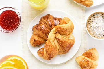 Breakfast with croissants, orange juice, raspberry jam
