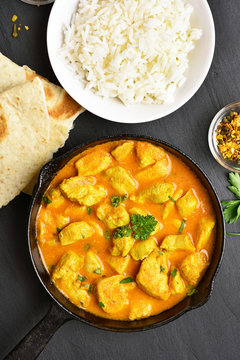 Indian chicken curry on black stone background with copy space. Top view, flat lay