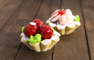bright cakes in the form of baskets on the background of a dark wooden table