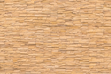 Rock stone brick tile wall aged texture detailed pattern background in dark yellow cream  brown color