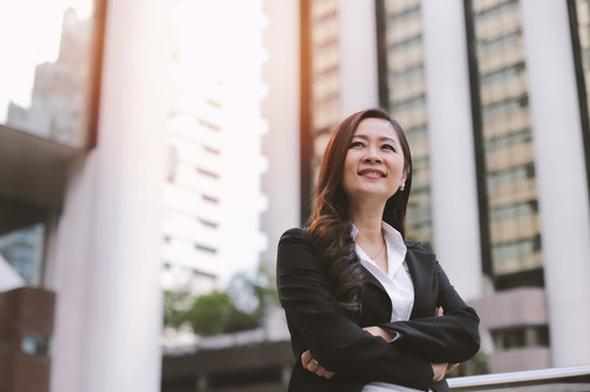Successful asian senior businesswoman leader standing over modern office background