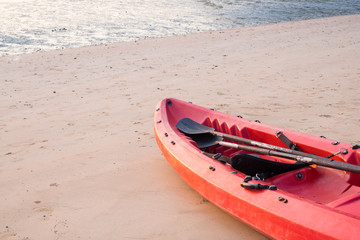 Canoe with paddle and life jacket on the beach in sunset or ocean background