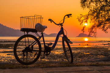 Fototapeta premium The silhouette of a bicycle on the beach with beautiful sunset