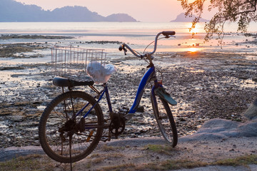 The silhouette of a bicycle on the beach with beautiful sunset