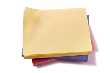 Stack of various different color oblong sticky post it note pads yellow on top isolated on white...