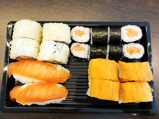 Sushi rolls holding by chopsticks. A traditional dish of Japanese cuisine.