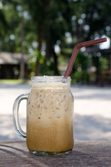 Iced coffee in glass on wooden