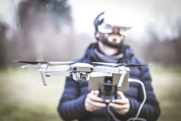 Young man with drone and virtual reality viewer
