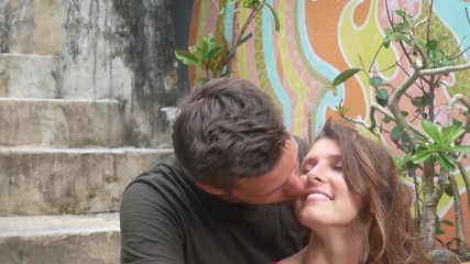 Couple hugging on the stairs and smiling to the camera