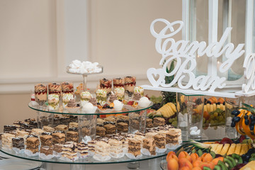 Candybar in a restaurant. Decorated white table fool of sweet pastry