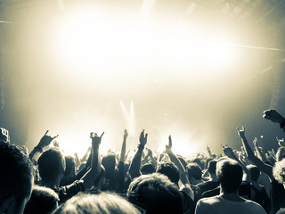 People clapping in front of a big concert stage