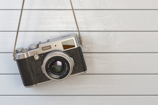 Vintage retro photo camera hanging on the white wooden wall.