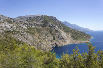 Dalmatian coastline with its cliff and streets through mountains, by the sea