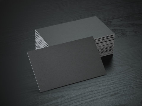 Stack of black blank business cards mockup on black wood table background,