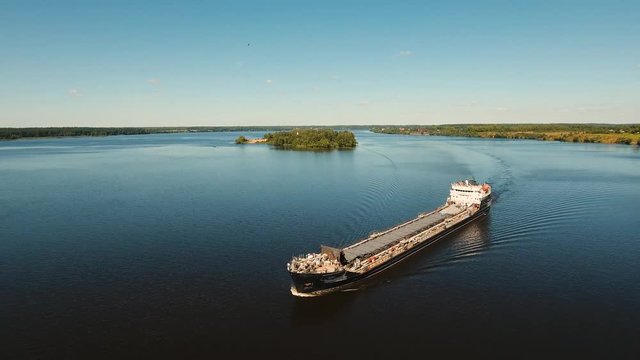 Aerial view:Barge with cargo on the river. River, cargo barge, highway with cars.. Cargo ship on the river.4K, aerial footage.