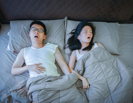 Asian Couple Sleeping On Bed In Bedroom, Top View