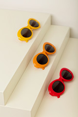 Sunglasses of red, orange and yellow colors on a white background.