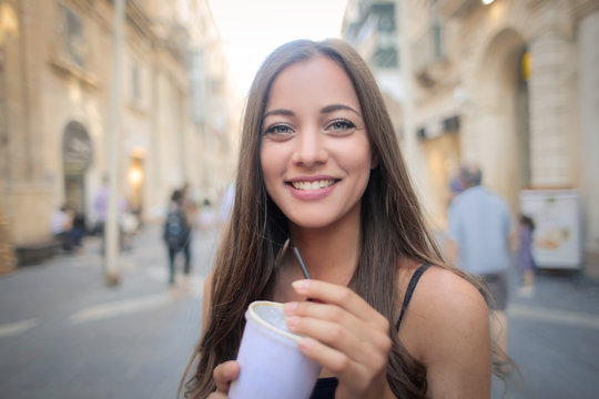 Smiling girl holding a drink