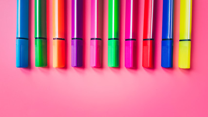 Set of multicolored markers on a pink background. Office tools. The concept of education and creativity.